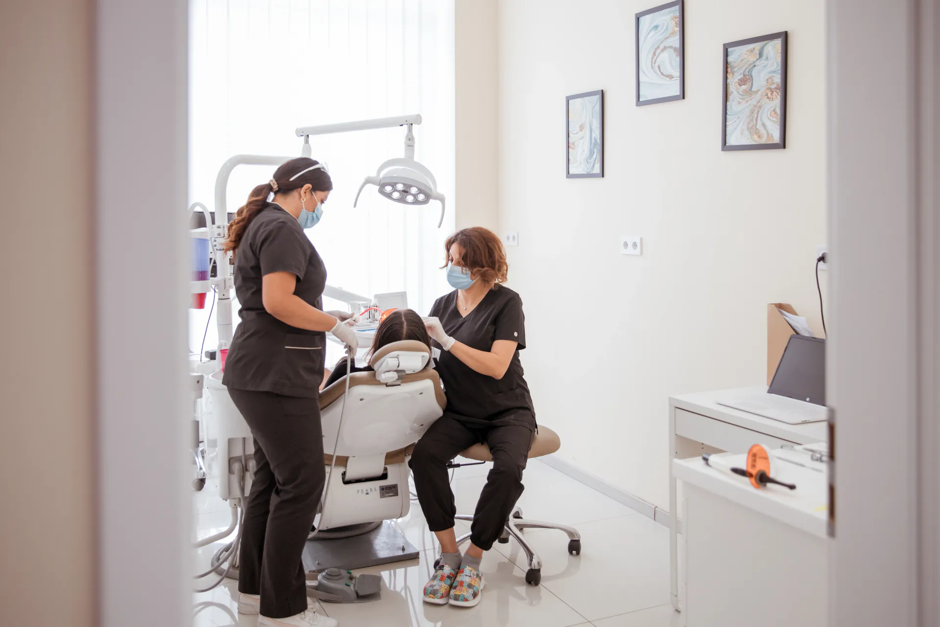 Dentists providing patient care in a bright treatment room at the Budapest clinic
